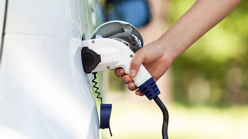 Close-up of person charging an electric car